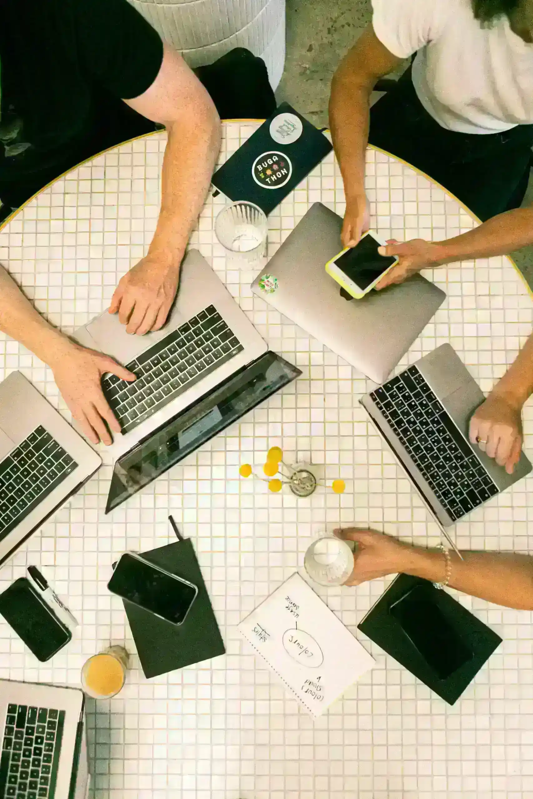 top view of desk with laptops and arms