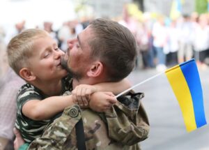 soldier holding child with Ukrainian flag