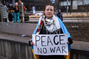 woman with sign saying peace no war