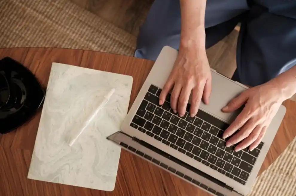 hands typing on a laptop