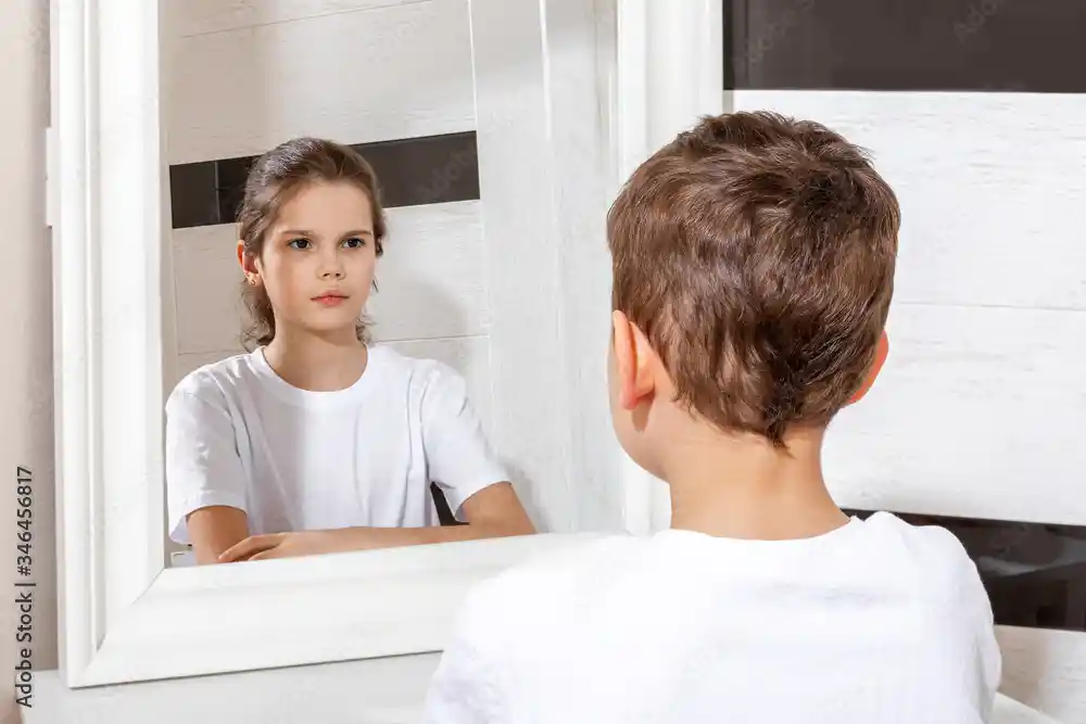 boy looking into a mirror seeing a girl