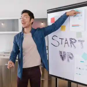 man next to whiteboard giving presentation