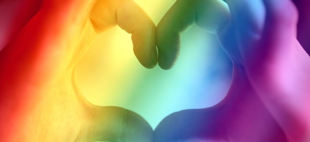 hands making a heart with rainbow colours
