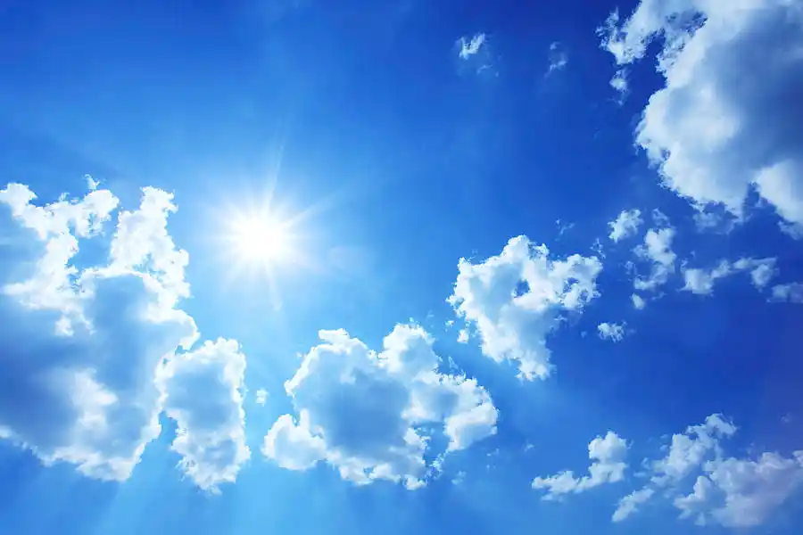 blue sky with sun shining and white clouds