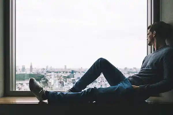 lonely man staring out a window