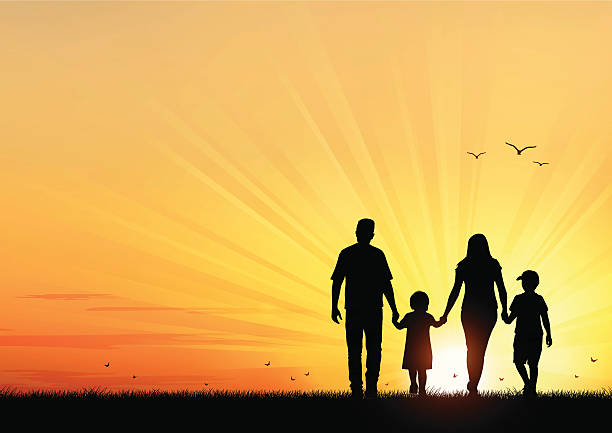 silhouette of happy family walking towards the sunset