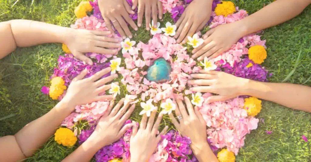 women gathering hands on a circle of flowers