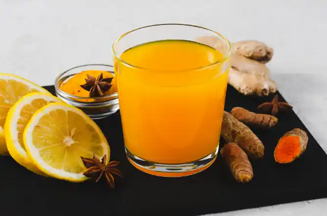 glass of orange juice with slices of lemon and aniseed and ginger