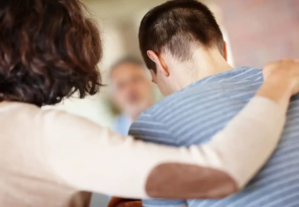 sad man being comforted by a woman